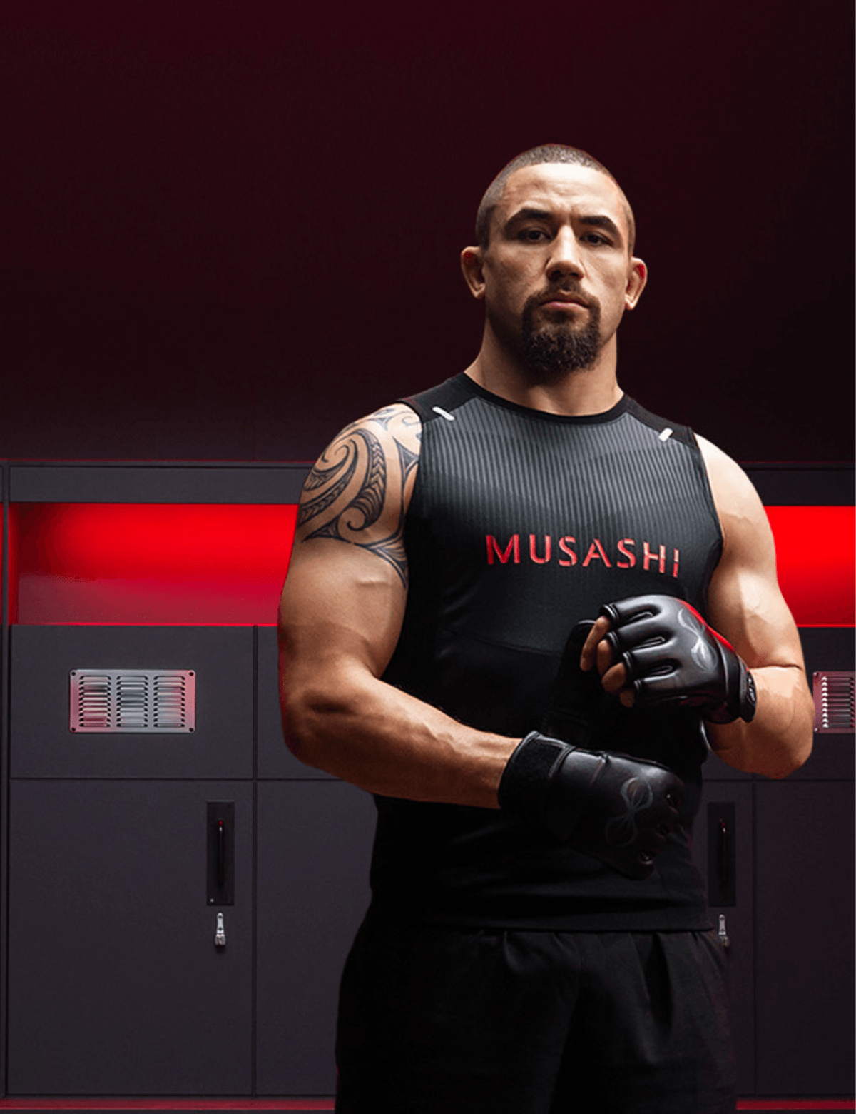 Robert Whittaker MMA champion, wearing a black 'MUSASHI' athletic shirt with tattoos and gloves, standing in a dark setting.